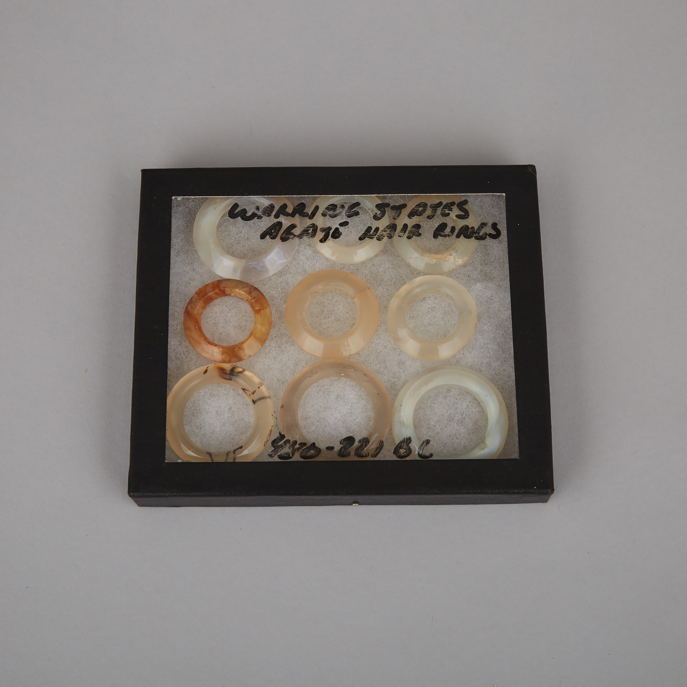 A Group of Nine Agate Bi Disc Hair Ring Pendants, Warring States Period, 5th to 3rd Century BC