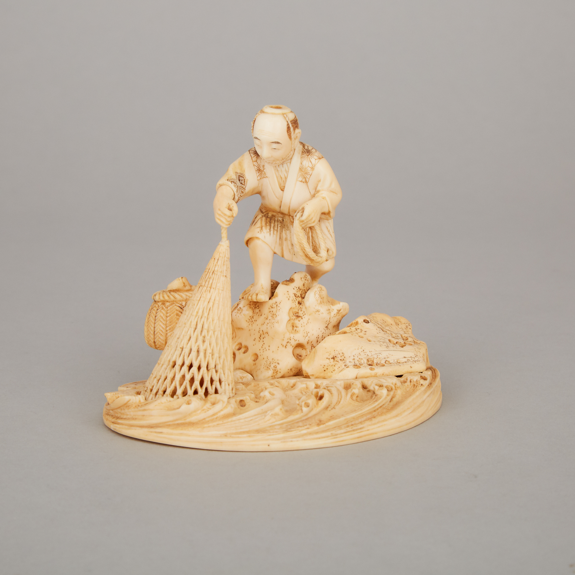 An Ivory Carved Okimono of a Fisherman, Meiji Period