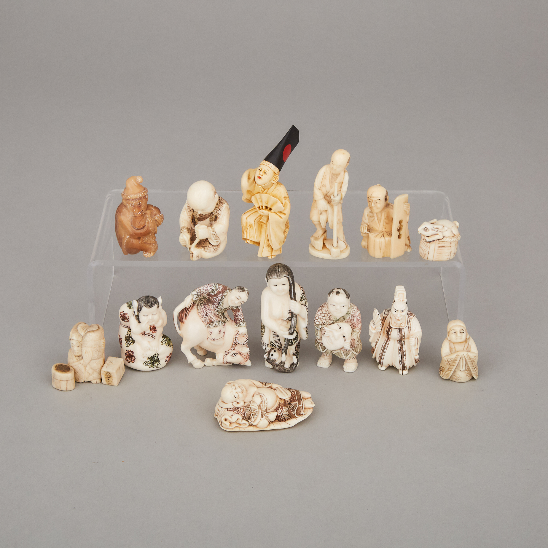 A Group of Fourteen Ivory, Bone, and Ivorine Nestuke