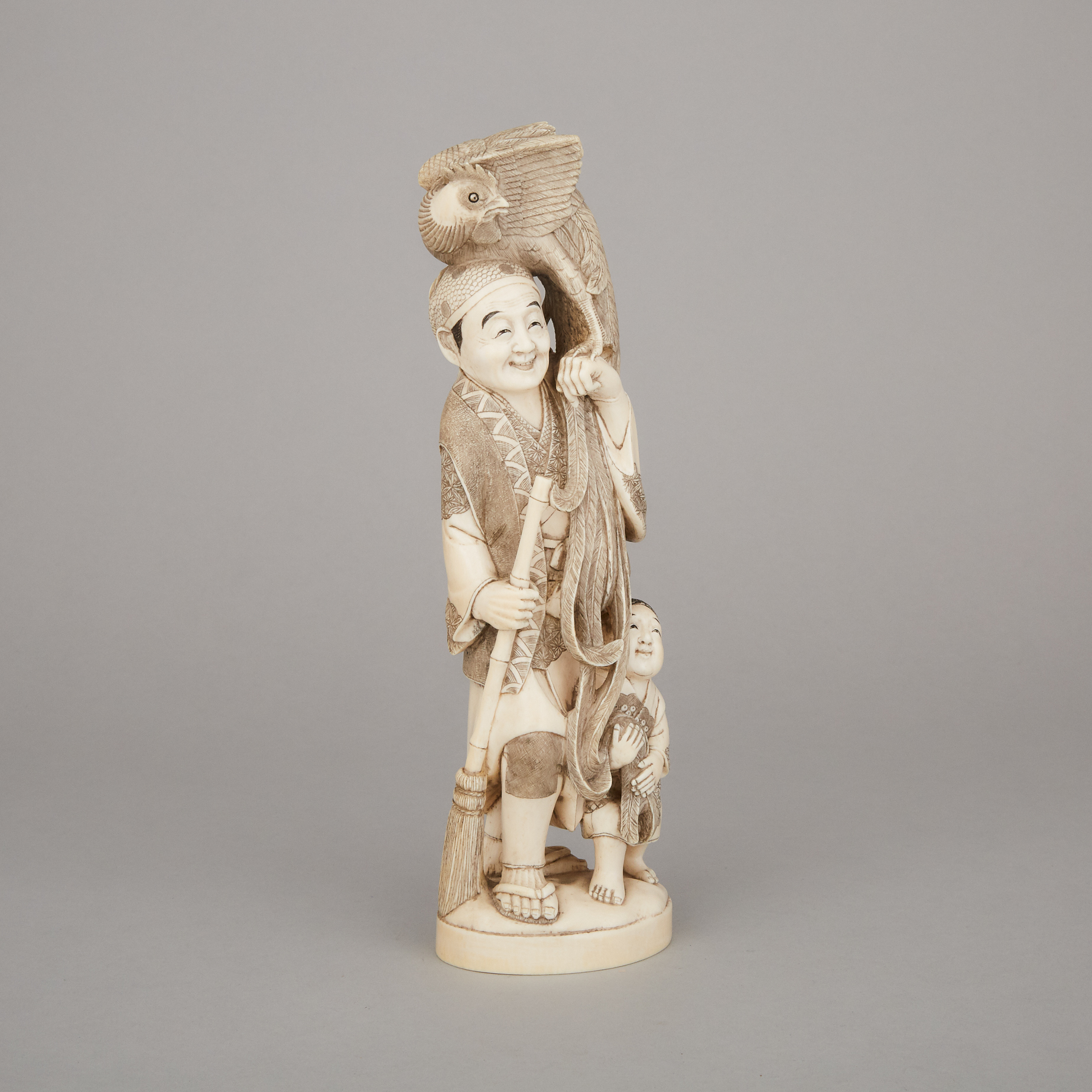 An Ivory Carved Okimono of an Old Man and a Phoenix, Early 20th Century
