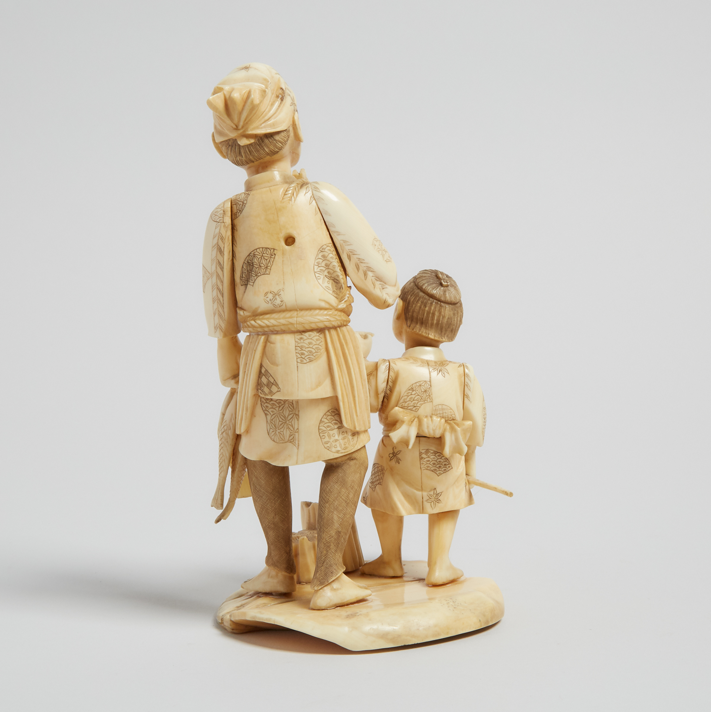 A Bone Carved Okimono of a Fisherman and Child, Early 20th Century