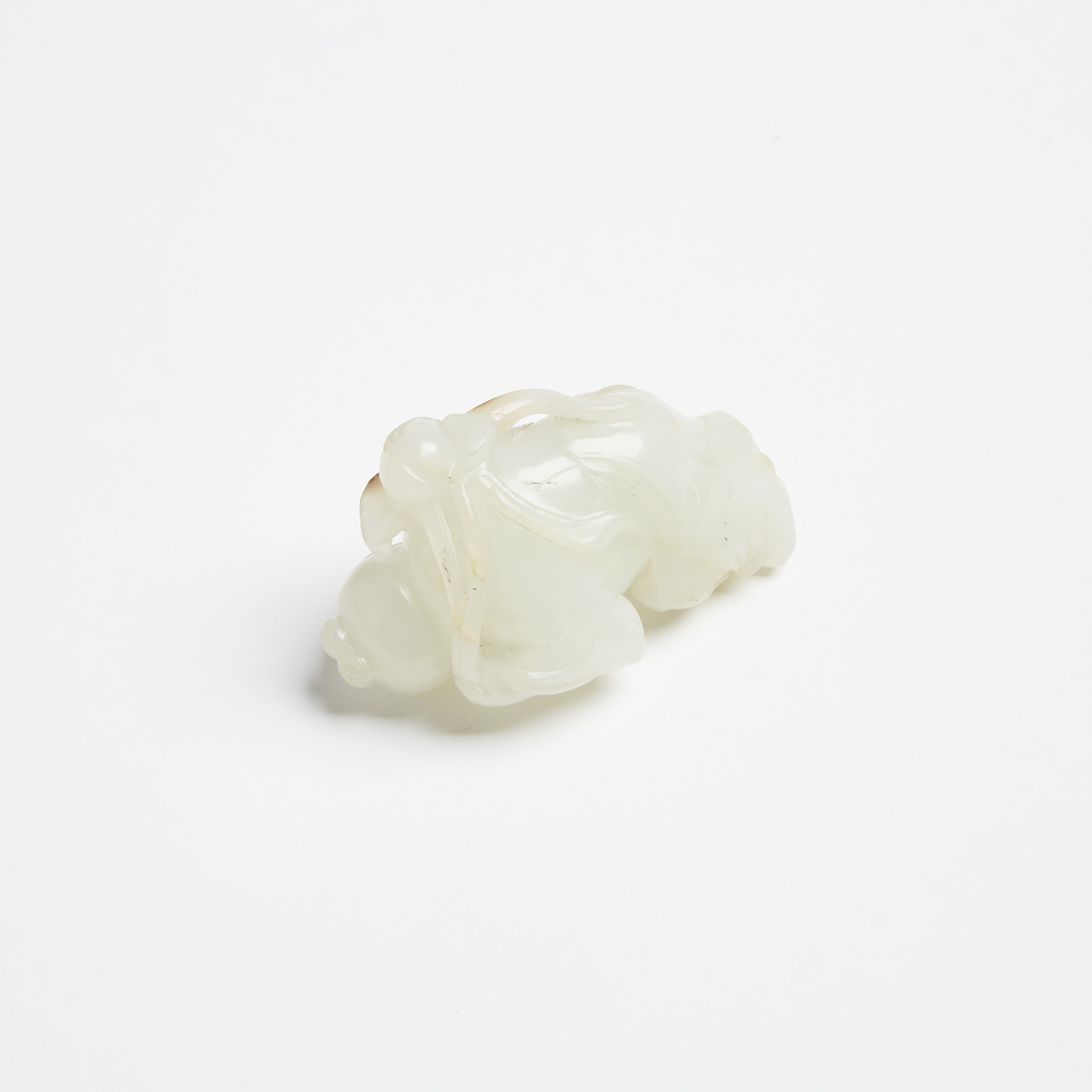 A White Jade and Russet Boy Holding Lotus Branch, Late Qing Dynasty