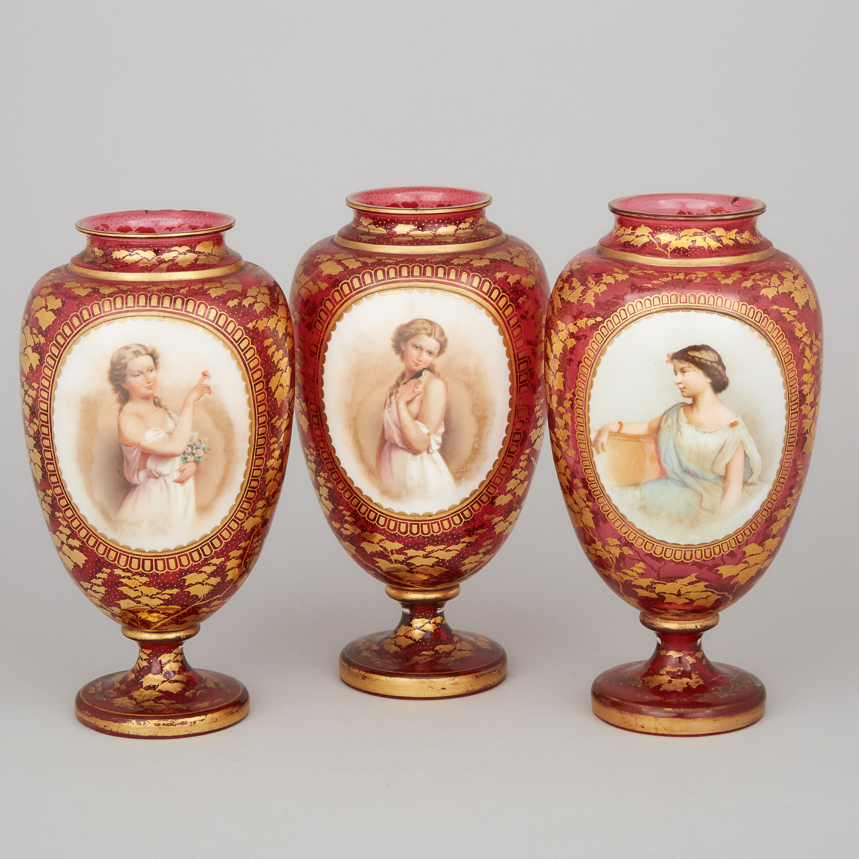 Bohemian Overlaid, Enameled and Gilt Red Glass Garniture of Three Portrait Vases, late 19th century