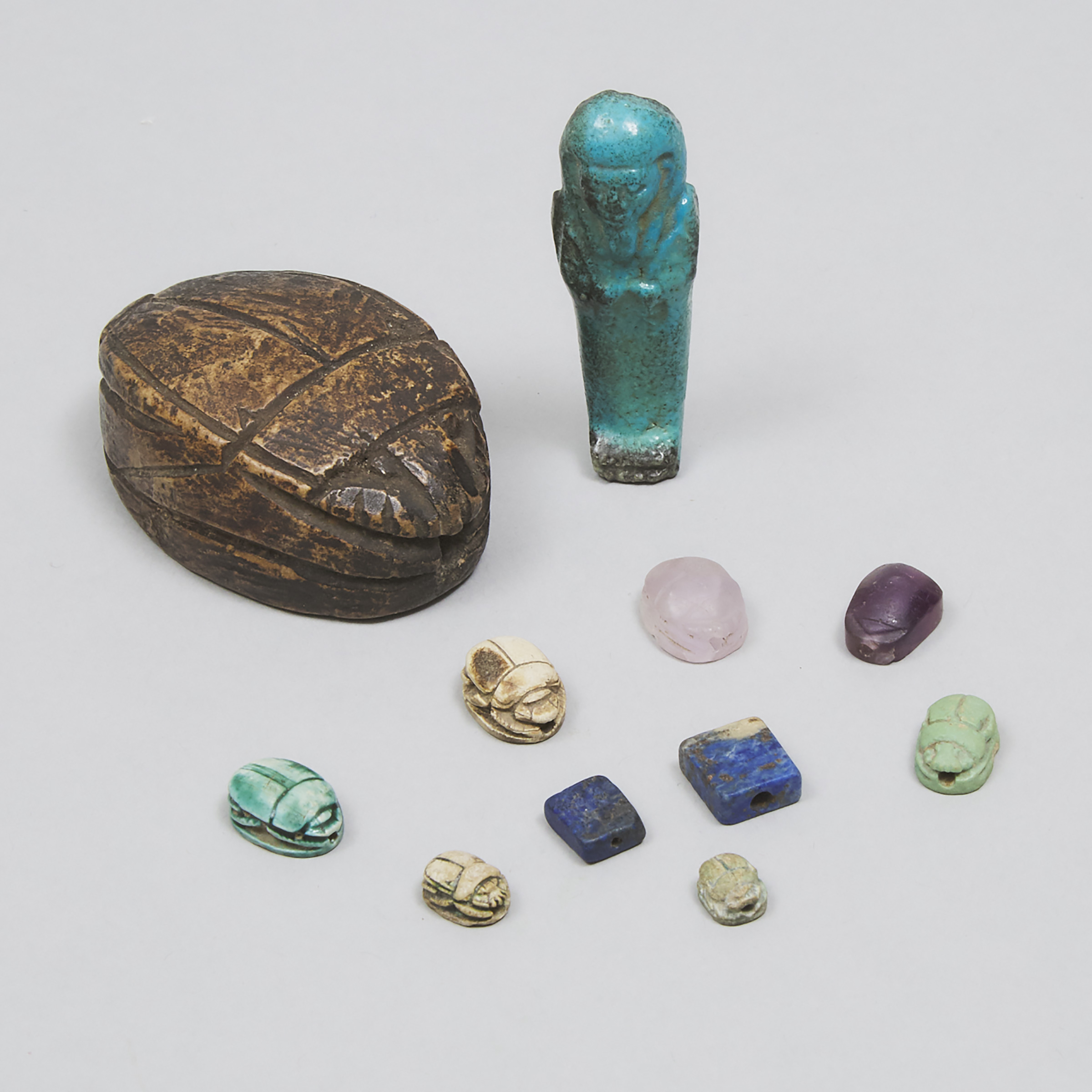 Group of Eight Egyptian Faience and Mineral Scarabs and an Ushabti, Third Intermediate Period and Later