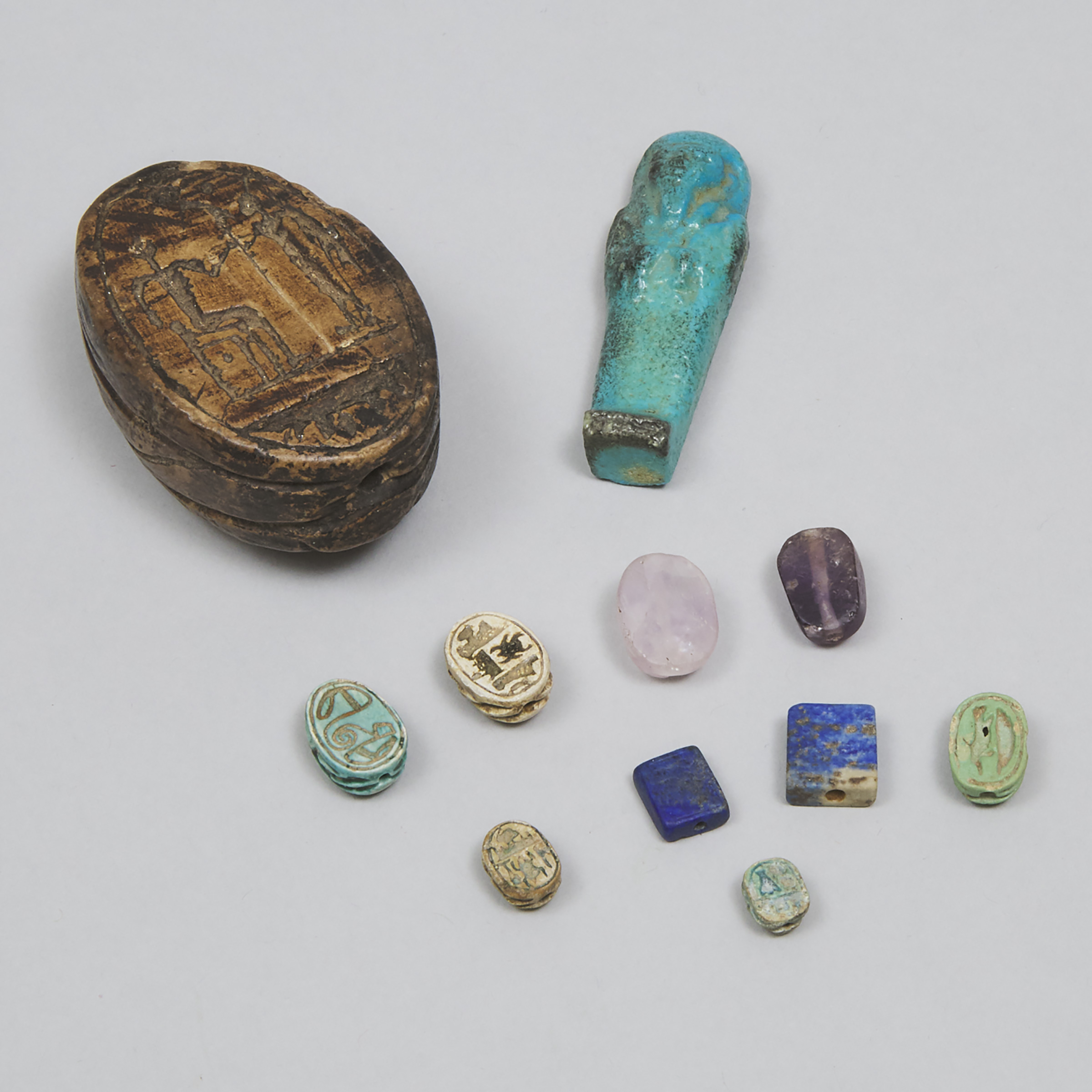 Group of Eight Egyptian Faience and Mineral Scarabs and an Ushabti, Third Intermediate Period and Later