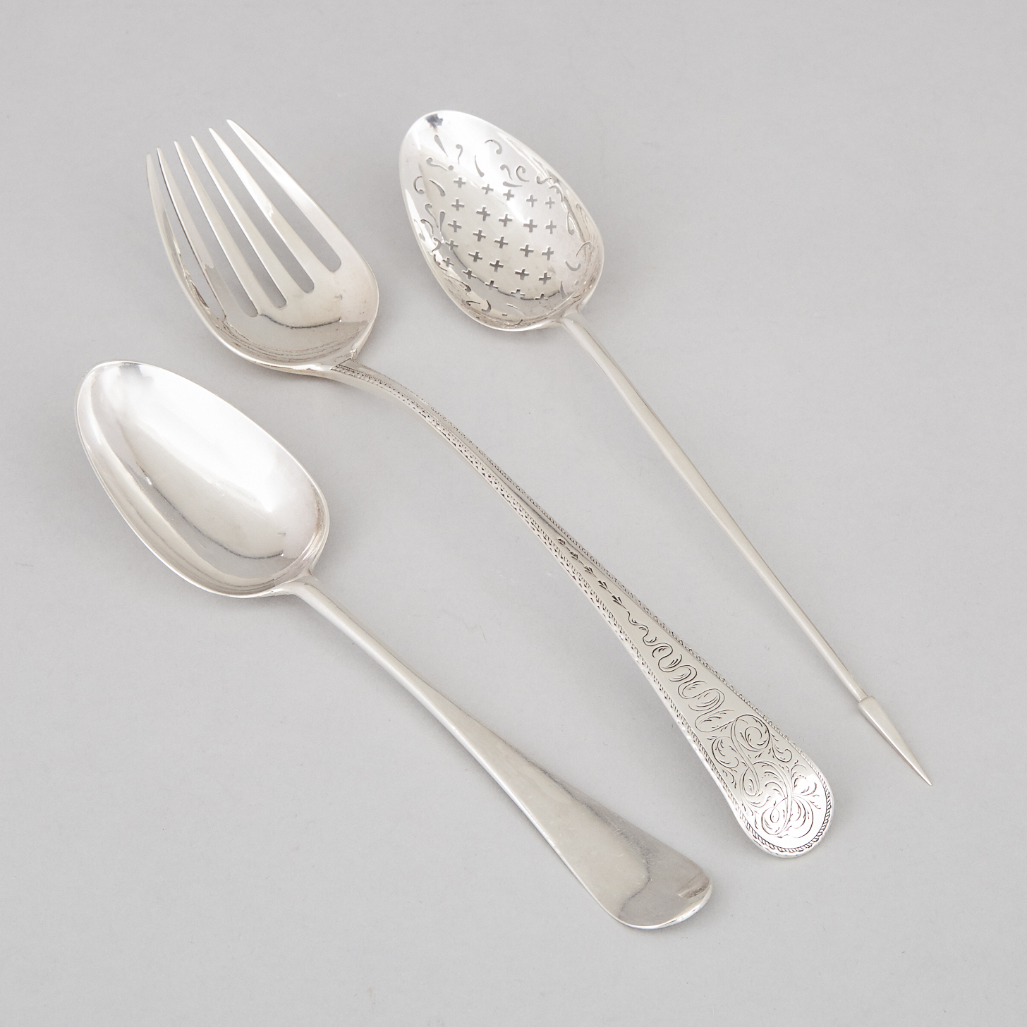George III Silver Large Mote or Straining Spoon, William London, London, 1764, Scroll-Backed Hanoverian Pattern Table Spoon, 1764, and an Engraved Old English Pattern Serving Fork, Richard Crossley, 1792
