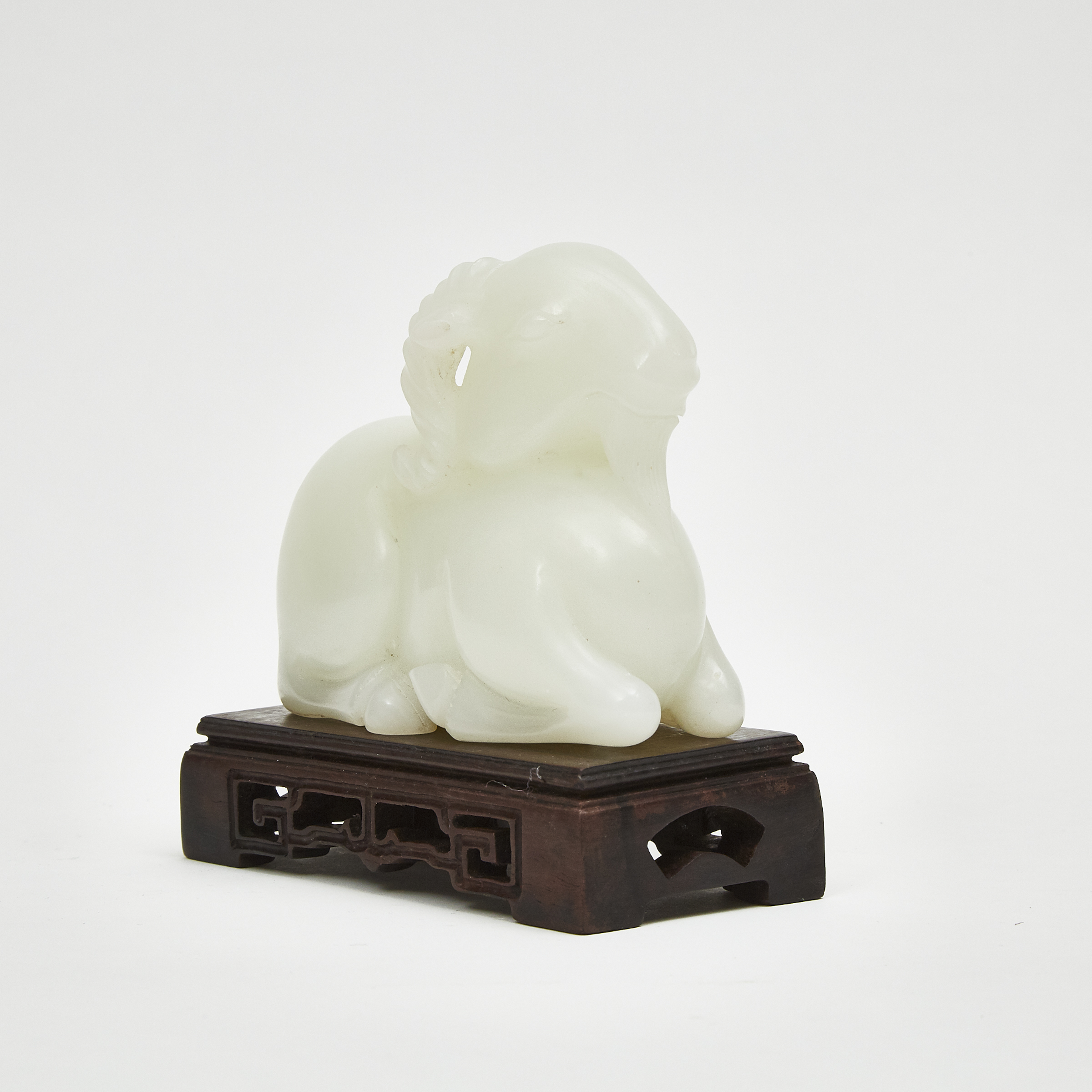 A Carved White Jade Recumbent Ram with Stand