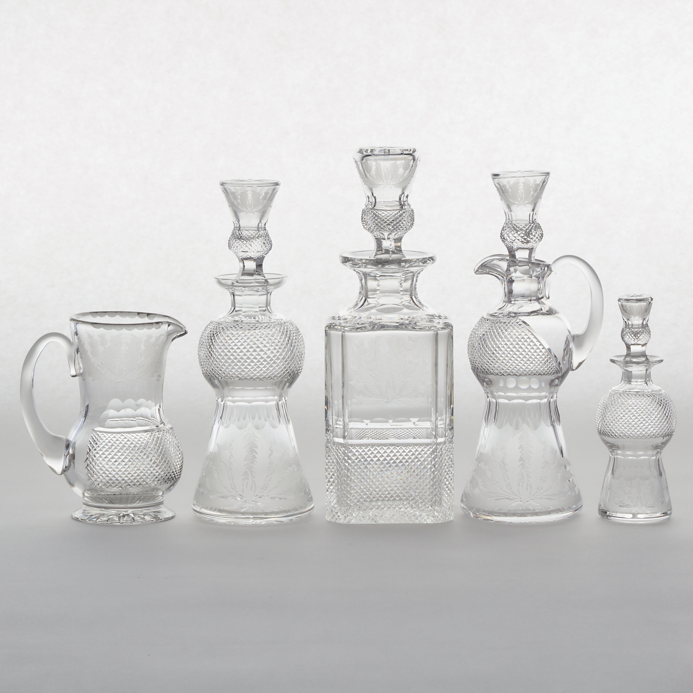 Four Edinburgh Crystal 'Thistle' Pattern Cut Glass Decanters and a Pitcher, 20th century
