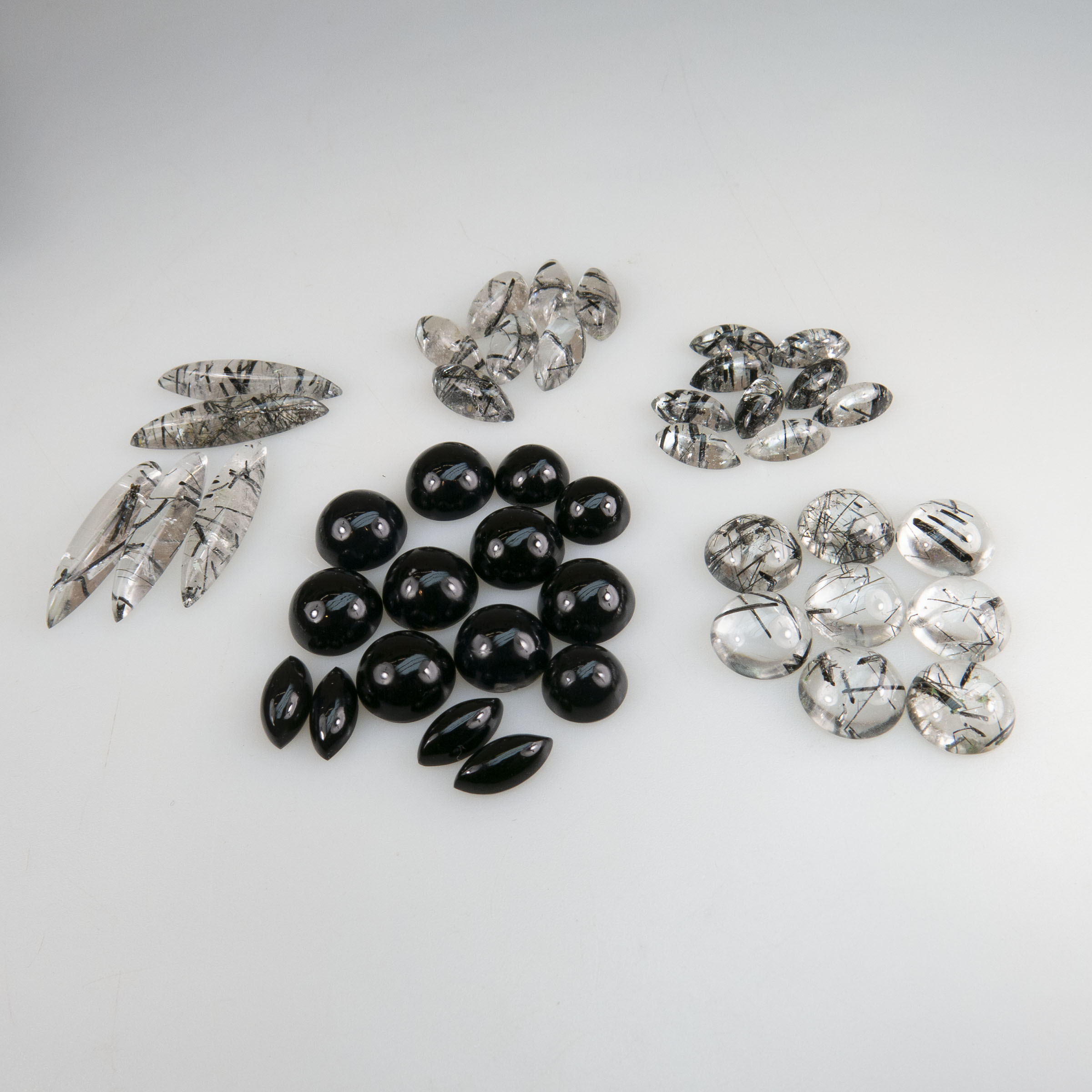 A Collection Of Onyx And Tourmalinated Quartz Cabochons
