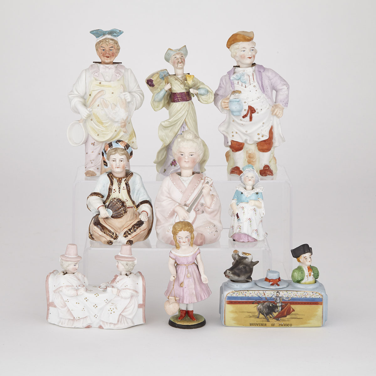 Nine Continental Bisque and Glazed  Porcelain Nodder Figures and Groups, late 19th/early 20th century