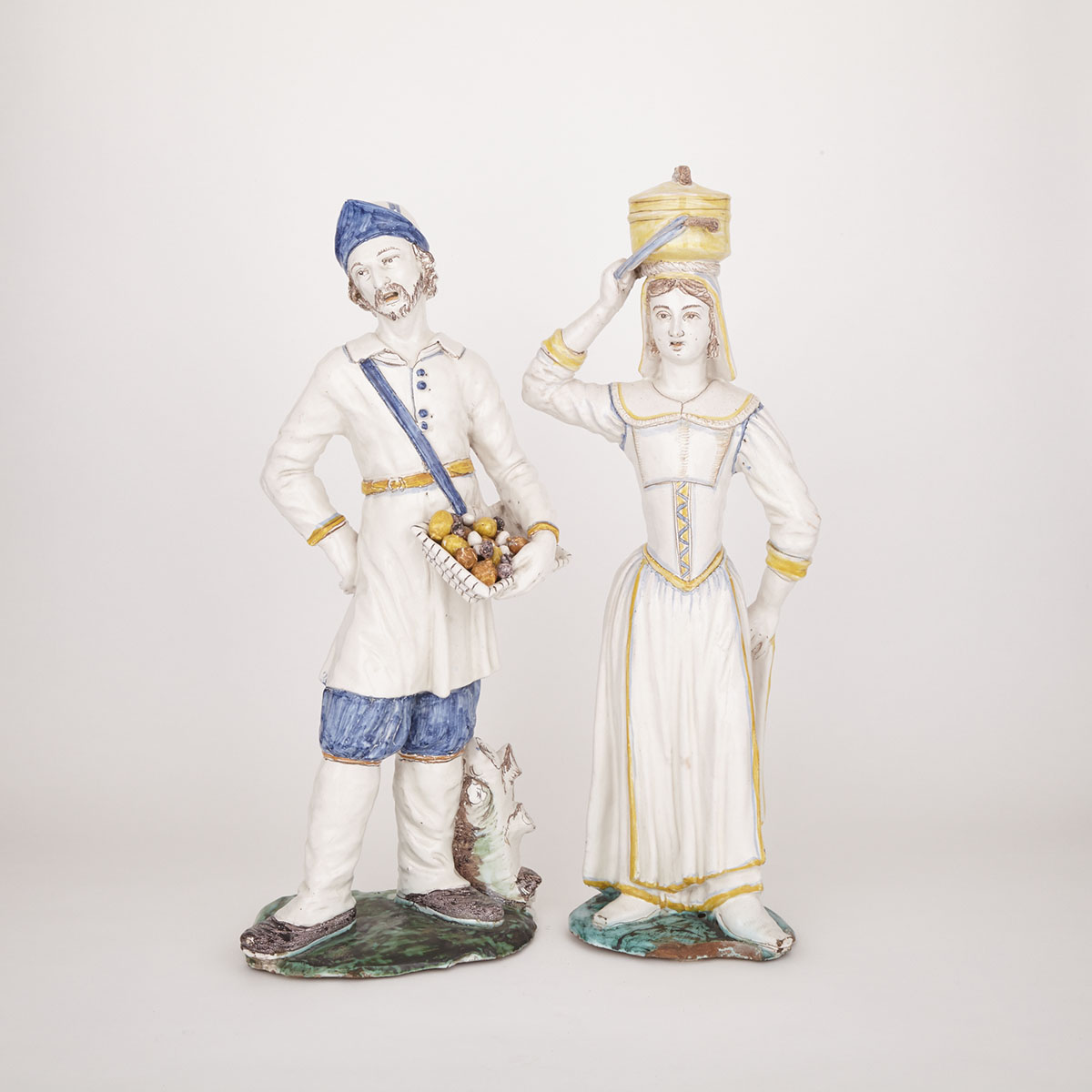 Pair of French Faience Figures of Peasant Street Vendors, probably Nevers, 17th century