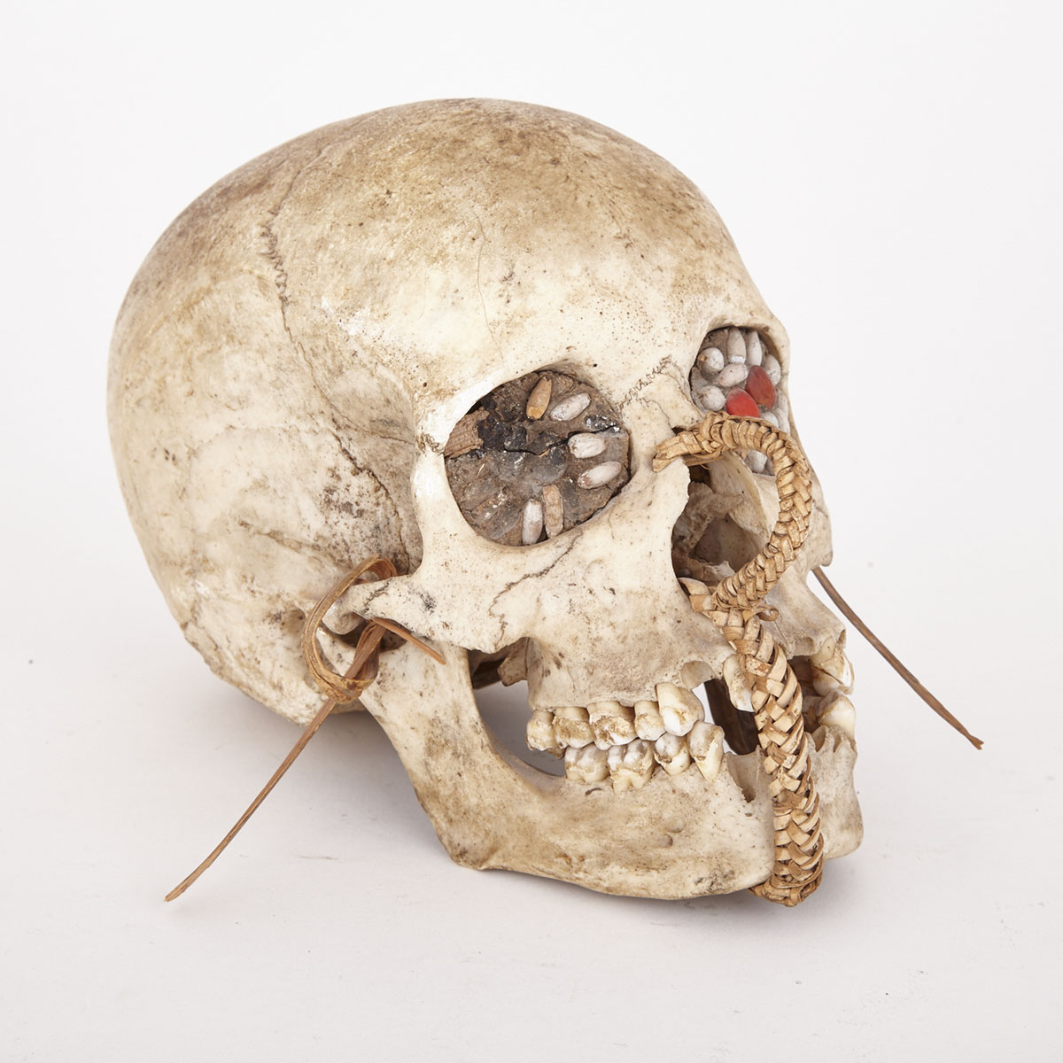 Asmat Ancestral Skull with woven cane decoration and seed inset eyes, Indonesia, West Papua, mid 20th century