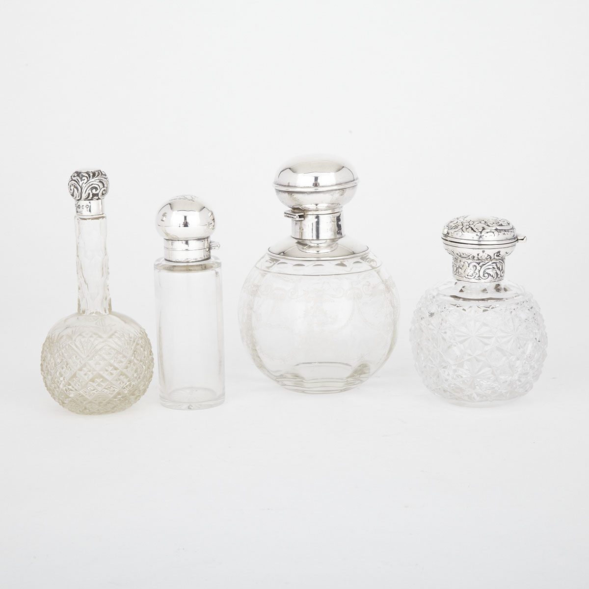 Four Victorian and Edwardian Silver Mounted Cut or Etched Glass Perfume and Toilet Water Bottles, London and Birmingham, 1897-1914